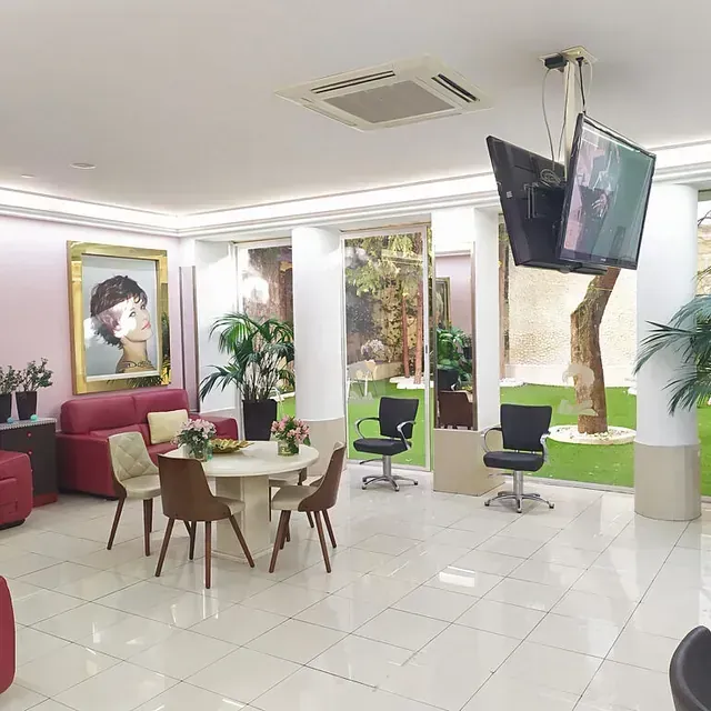 Una sala de estar con una mesa y sillas y un televisor colgando del techo.