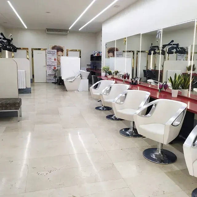 Una fila de sillas blancas en una peluquería