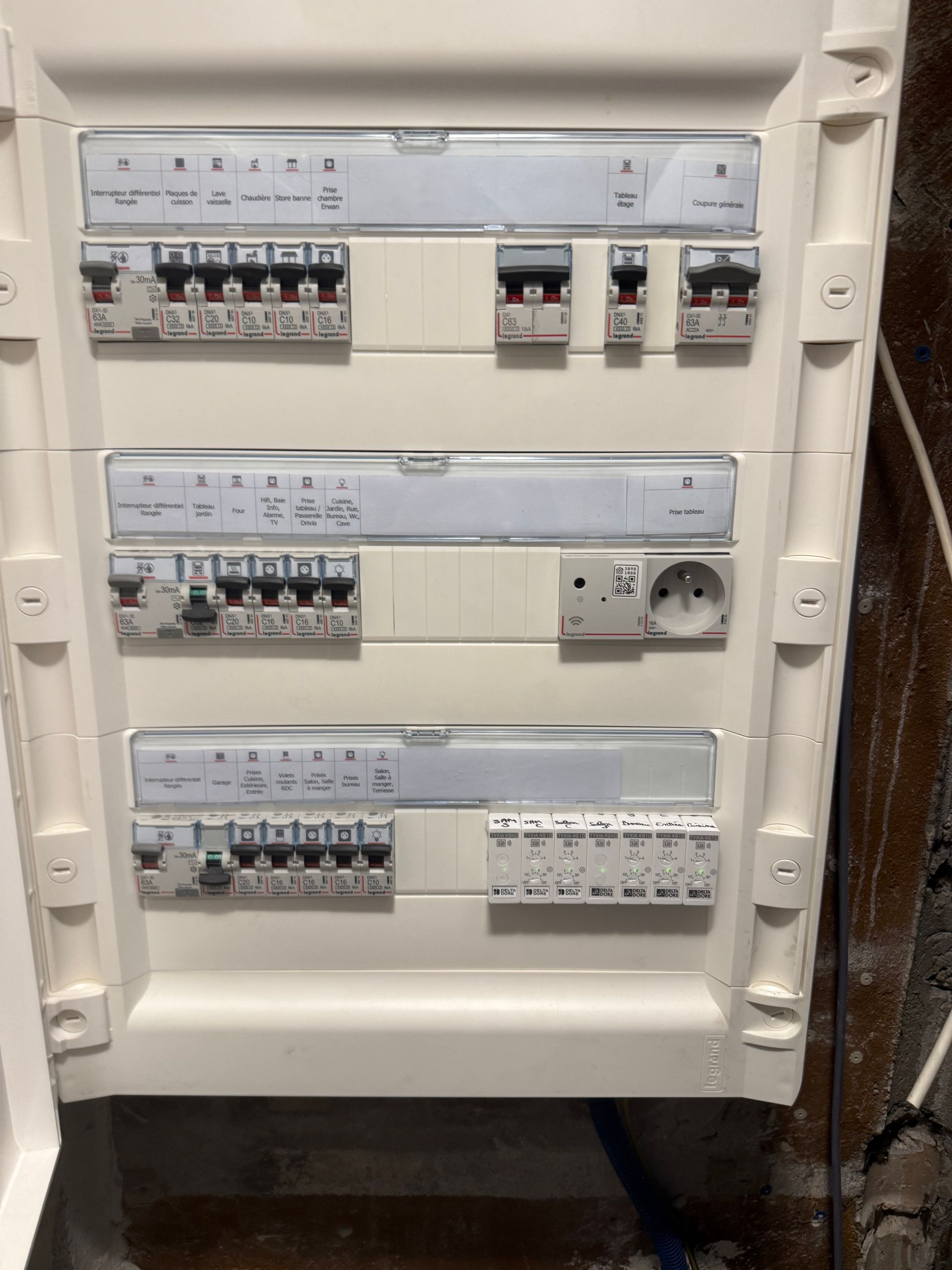 Tableau électrique ouvert avec des rangées de disjoncteurs et d'interrupteurs.