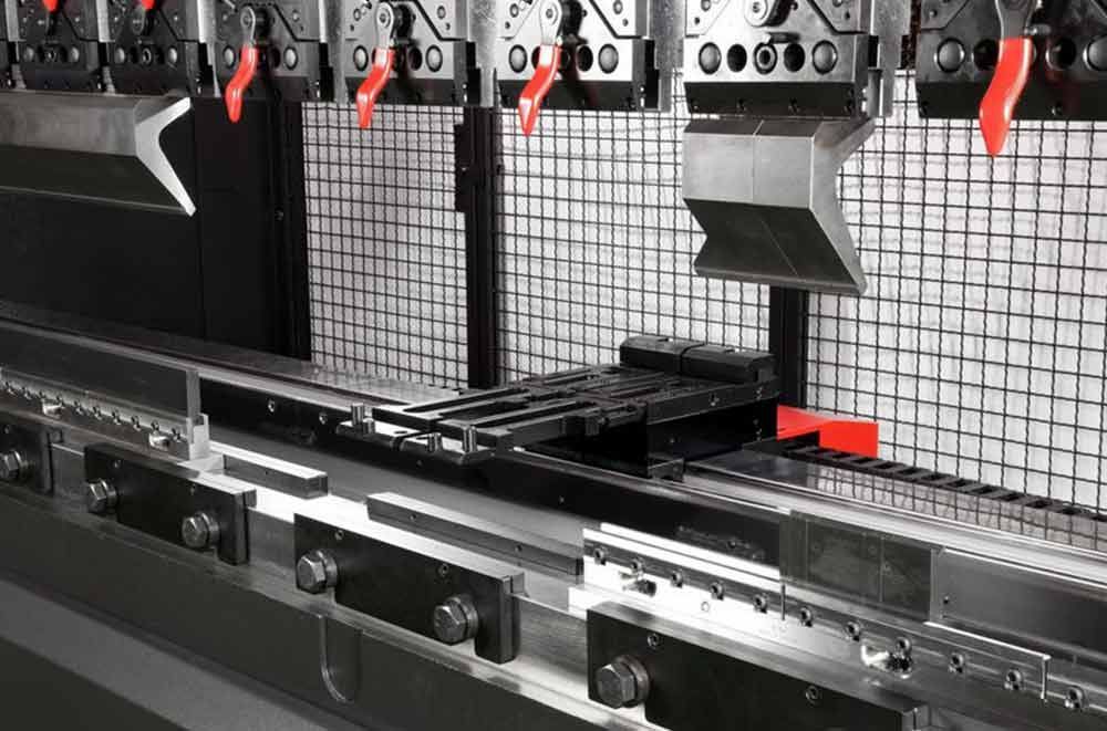 Eine Maschine schneidet ein Stück Metall auf einem Förderband.