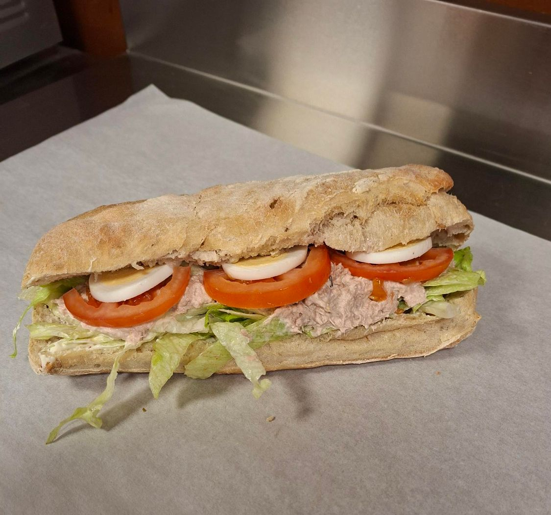 photorealistic artisan bakery counter with fresh sandwiches and salads natural light warm atmosphere