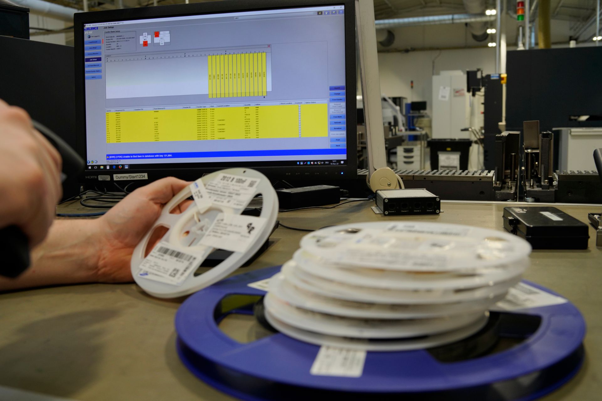 Eine Person reinigt eine Computerhauptplatine mit einer Spritze und Wattestäbchen