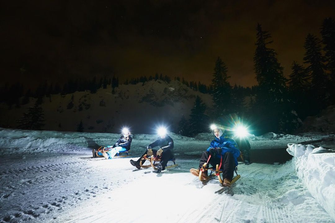 Descente en luge de nuit avec lampe frontale