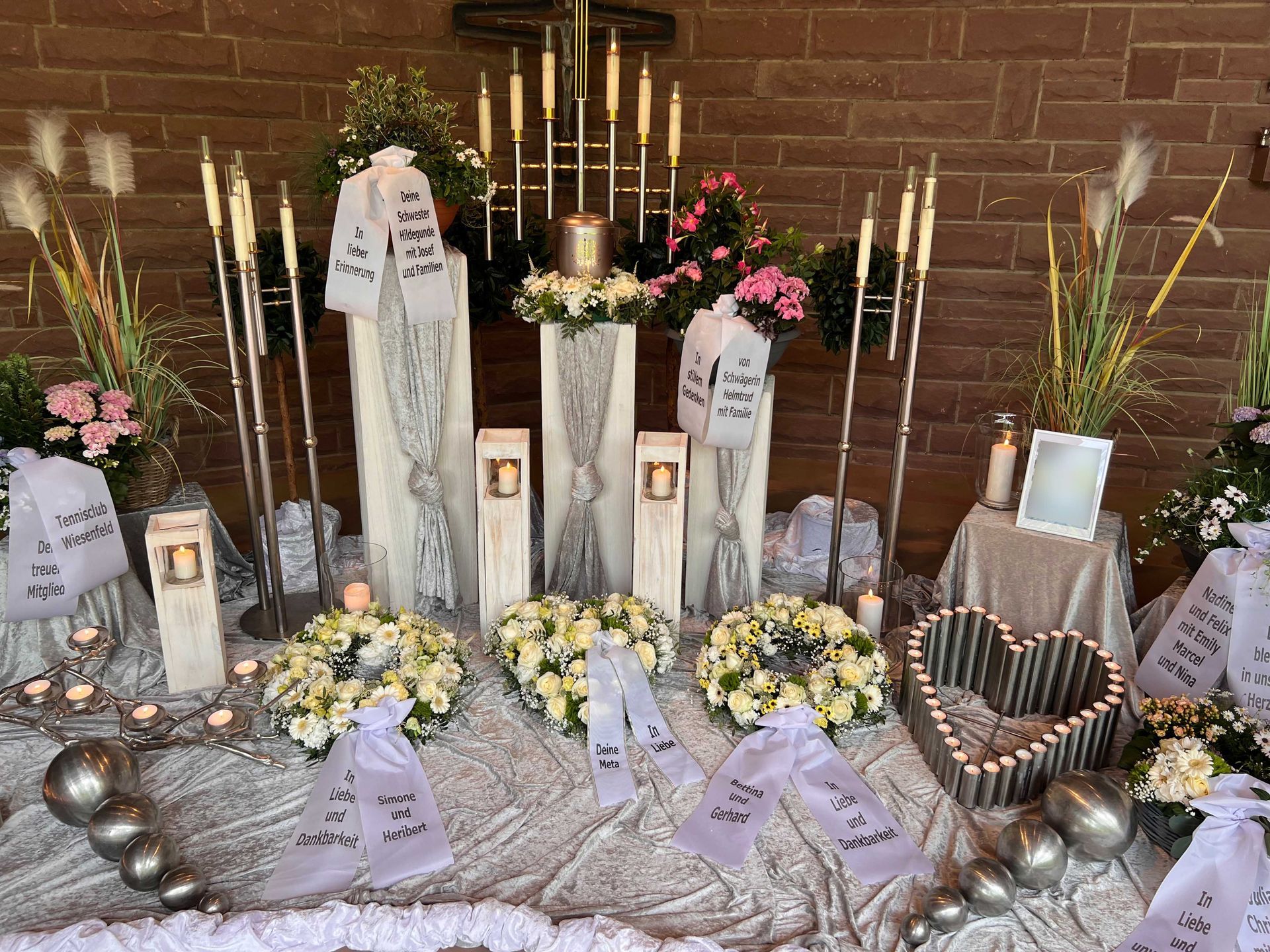 Blumenschmuck, Grablichter und Kerzen als Grabdekoration bei einer Trauerfeier