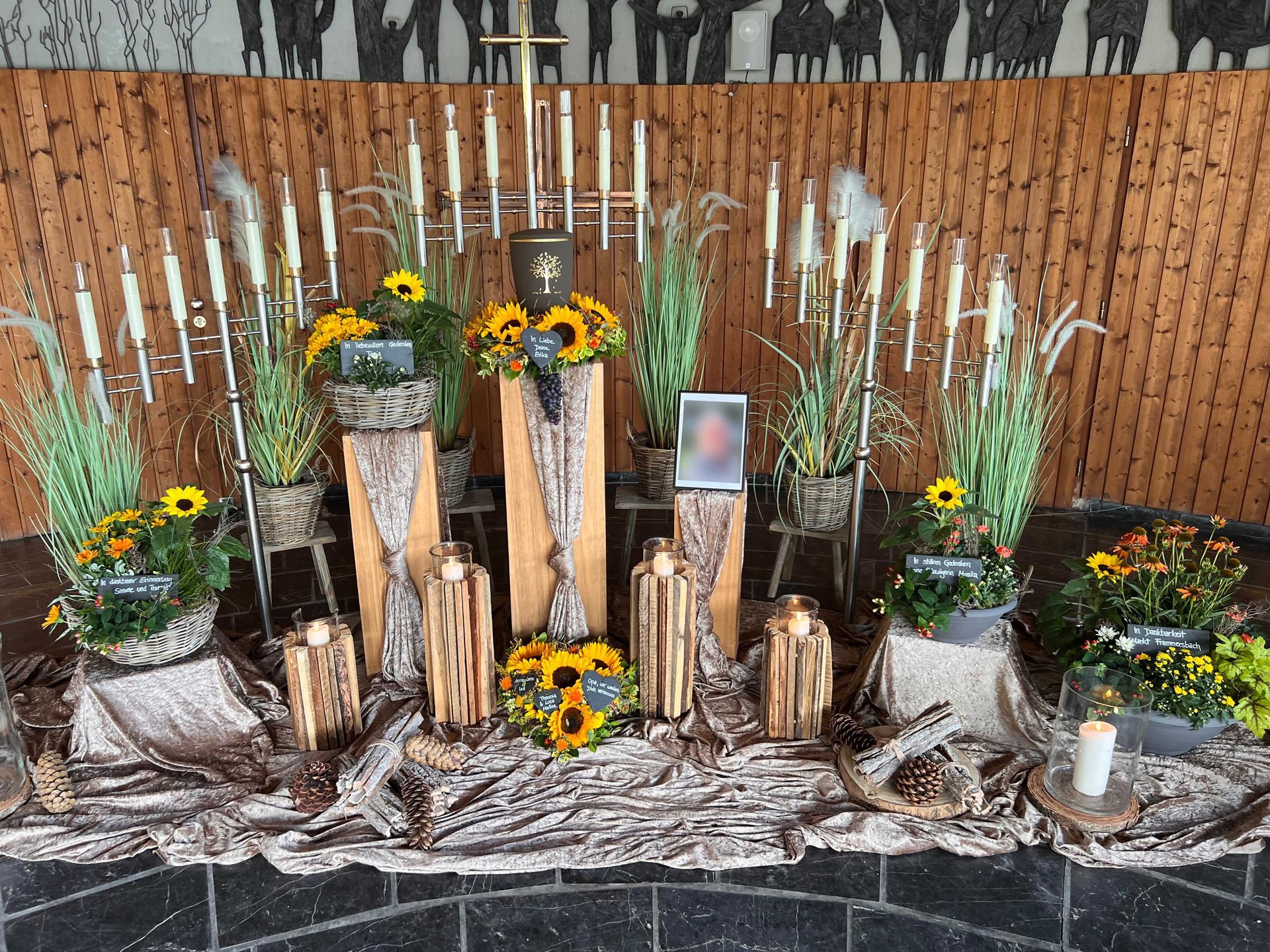 Trauerfeier mit Blumenschmuck, Kerzen und Grablichtern als Grabdekoration