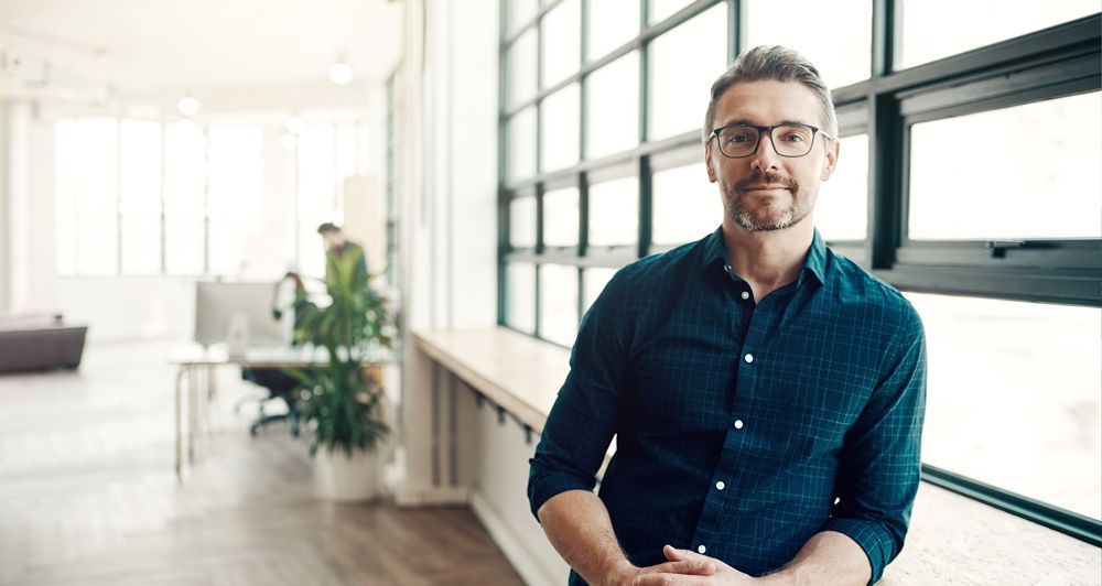 Homme assis devant une fenêtre.