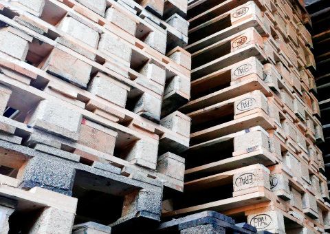 Una pila de paletas de madera apiladas una encima de otra en un almacén.