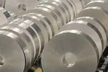 Um monte de rolos de papel alumínio empilhados uns sobre os outros em uma fábrica.