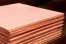 Uma pilha de folhas de cobre colocadas umas sobre as outras sobre uma mesa.