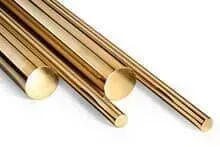 Três hastes de latão empilhadas uma sobre a outra sobre uma superfície branca.
