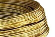 Um close de uma bobina de fio de latão em um fundo branco.