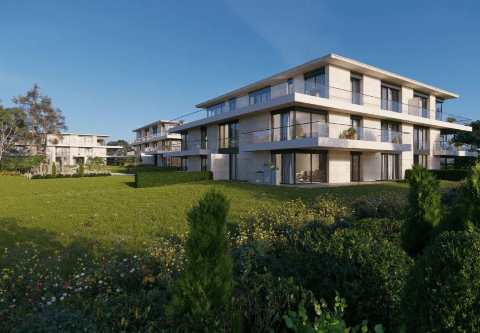 Une impression d'artiste d'un immeuble d'appartements moderne avec une grande pelouse devant lui.