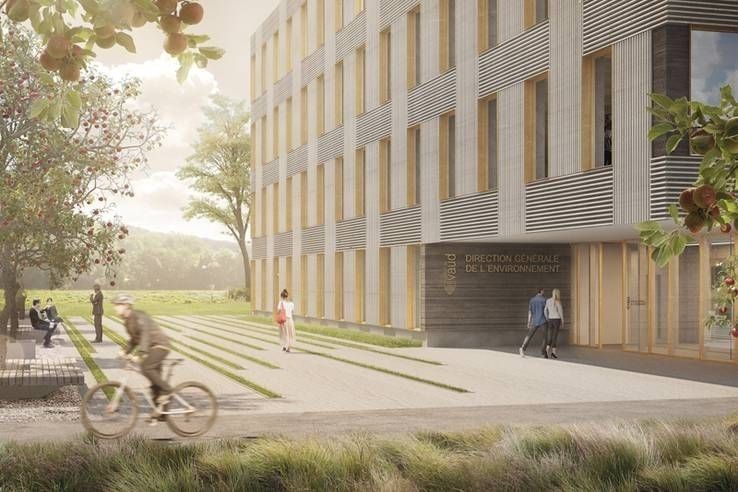 Un homme fait du vélo devant un grand bâtiment.