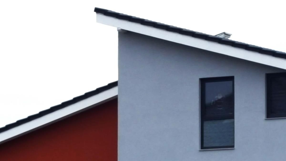 Ein rot-weißes Haus mit einem asymmetrischen Dach