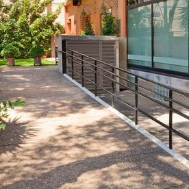 Una rampa amb barana que condueix a un edifici.