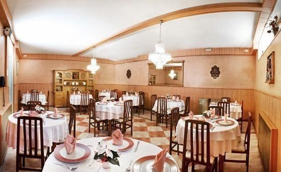 Un restaurant amb taules i cadires parades per sopar