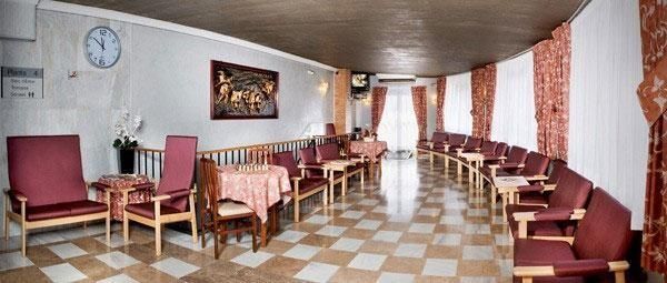 Una sala gran amb taules i cadires i un rellotge a la paret.