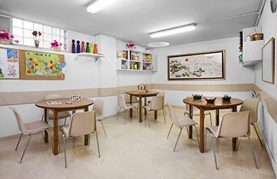 Una habitació amb taules i cadires i un quadre a la paret.