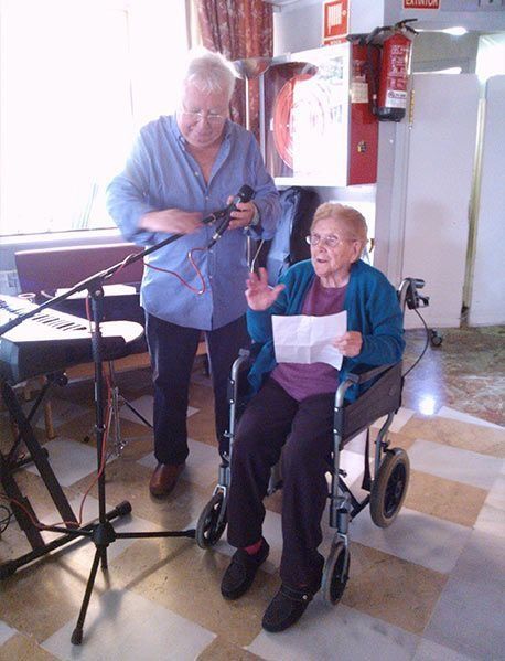 Una dona gran en cadira de rodes canta en un micròfon