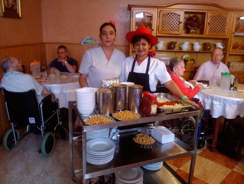 Una dona amb un barret vermell està dreta al costat d'un carretó de menjar