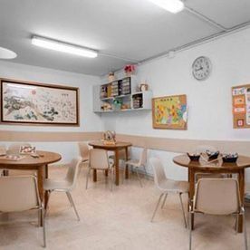 Una habitació amb taules i cadires i un rellotge a la paret.