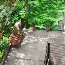 Vista aèria d'un pati amb un banc i plantes en test.