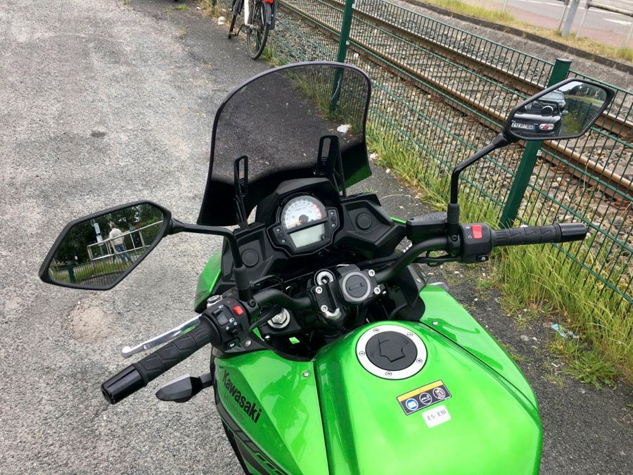 Ein grünes Kawasaki-Motorrad ist am Straßenrand geparkt.