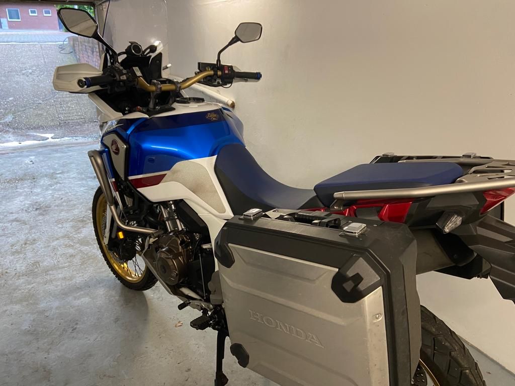 In einer Garage steht ein blau-weißes Motorrad.