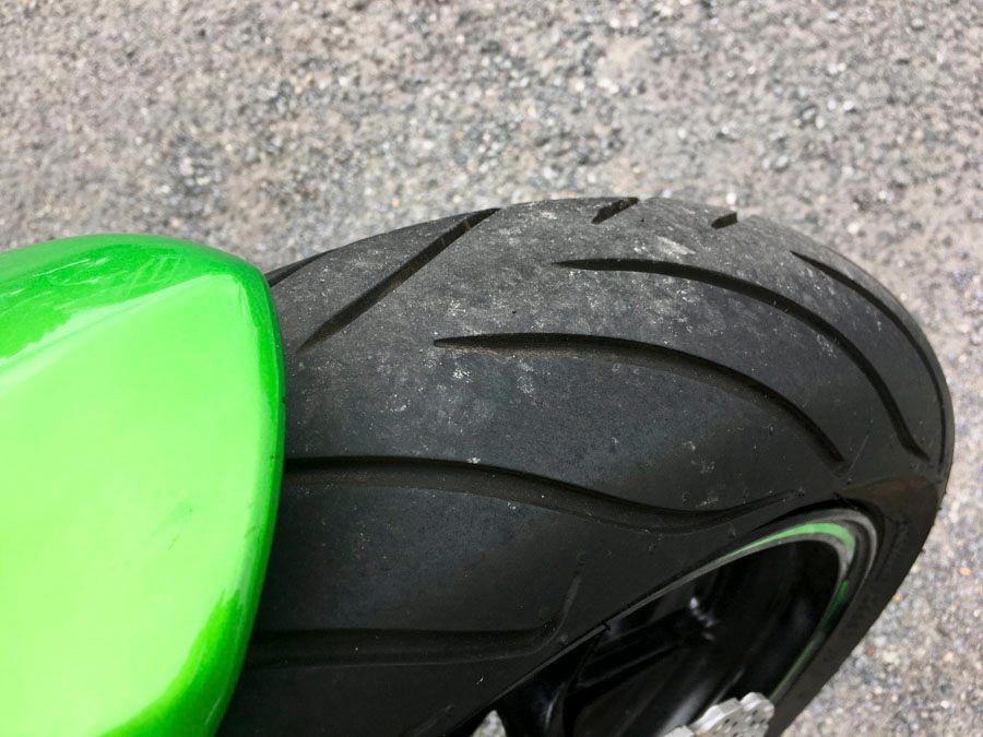 Eine Nahaufnahme eines Motorradreifens auf einer Straße.