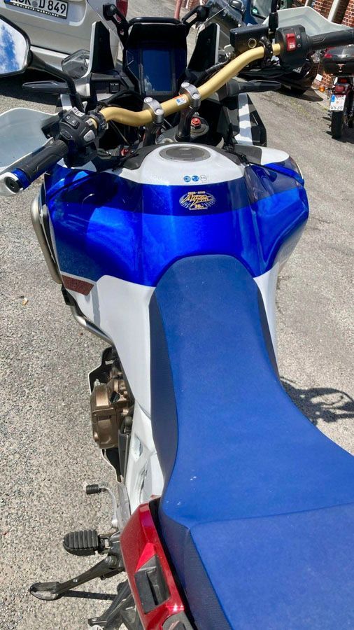 Am Straßenrand parkt ein blau-weißes Motorrad.