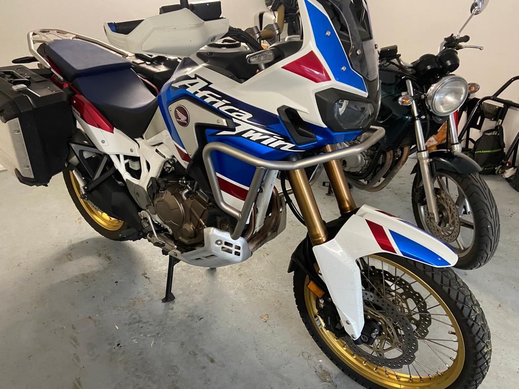 Zwei Motorräder sind nebeneinander in einer Garage geparkt.