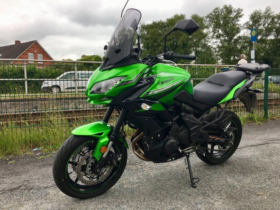 Ein grünes Kawasaki-Motorrad ist am Straßenrand geparkt.