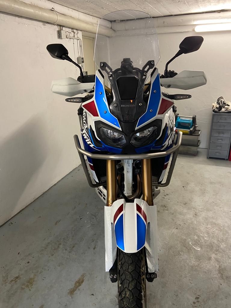 In einer Garage steht ein rot-weiß-blaues Motorrad.