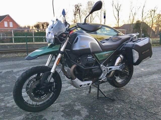 Auf einem Parkplatz steht neben einem Auto ein Motorrad.