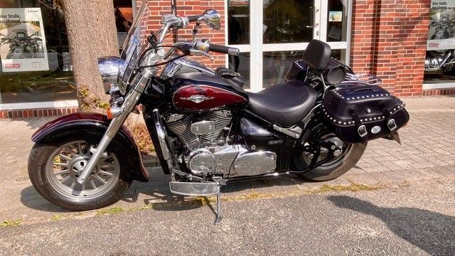 Vor einem Backsteingebäude ist ein Motorrad geparkt.