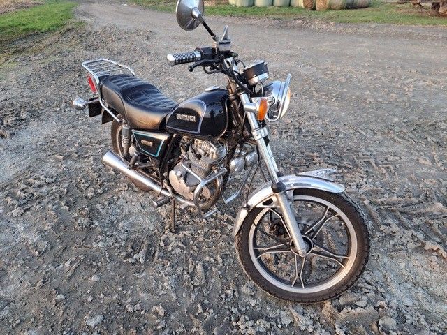 Ein schwarzes Motorrad ist auf einer unbefestigten Straße geparkt