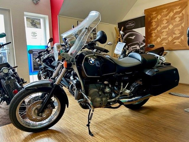 Ein BMW-Motorrad ist in einem Raum mit anderen Motorrädern geparkt.