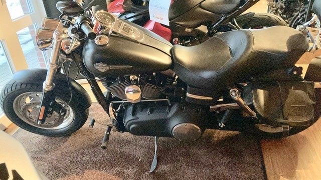 Ein schwarzes Harley-Davidson-Motorrad steht auf einem Teppich in einem Zimmer.