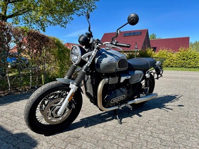 Ein Motorrad ist am Straßenrand vor einem Haus geparkt.