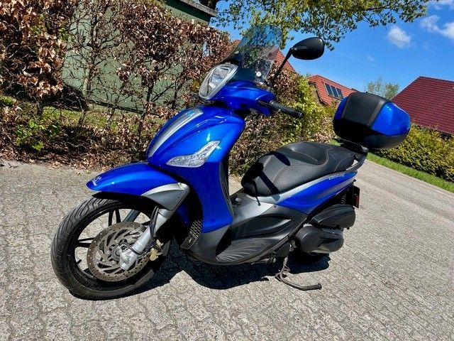 Ein blauer Roller steht am Straßenrand