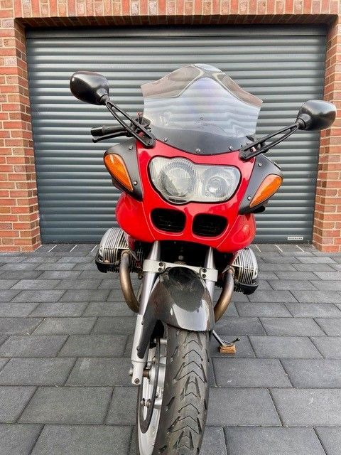 Ein rotes Motorrad steht vor einem Garagentor
