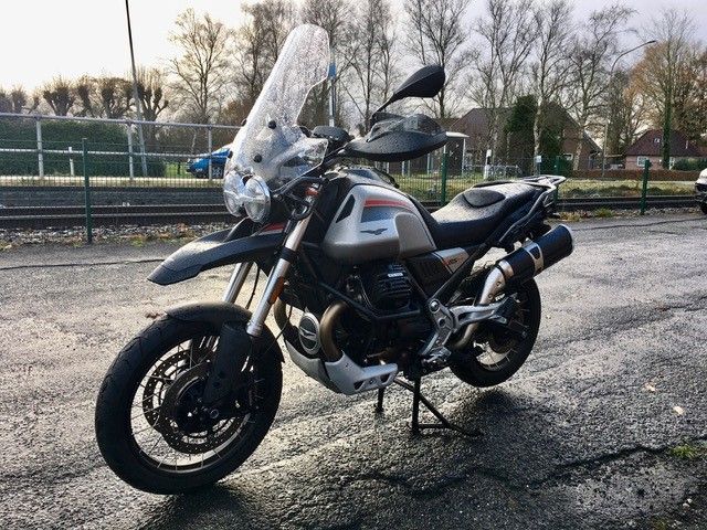 Ein Motorrad mit Windschutzscheibe steht am Straßenrand