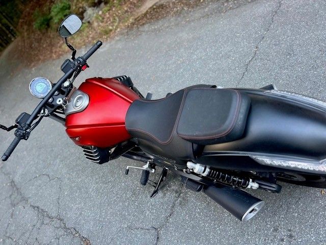 Rotes Motorrad, geparkt am Straßenrand mit Rissen, Ansicht von oben.