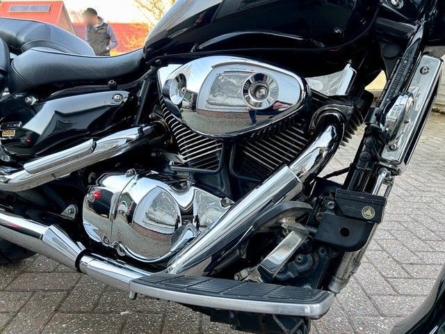 Eine Nahaufnahme eines Motorradmotors auf einer Ziegelsteinstraße.