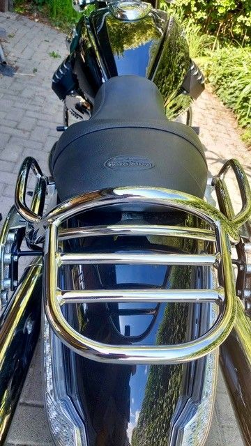 Glänzend schwarzes Motorradheck mit verchromtem Gepäckträger und Sitz.