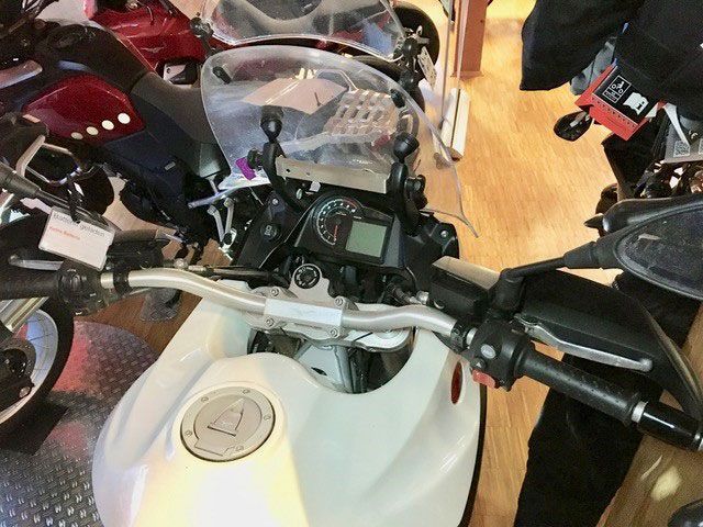 In einem Ausstellungsraum steht ein weißes Motorrad.