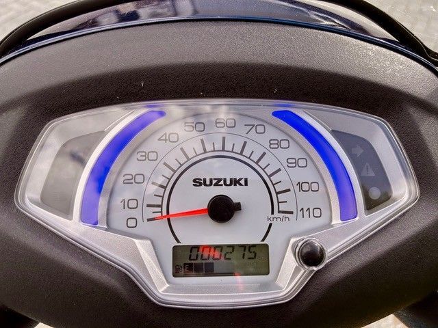 Eine Nahaufnahme von einem Tachometer auf einem Suzuki-Roller
