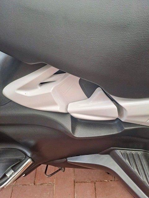 Eine Nahaufnahme eines Rollersitzes und des umgebenden Kunststoffrahmens in den Farben Schwarz und Hellgrau.