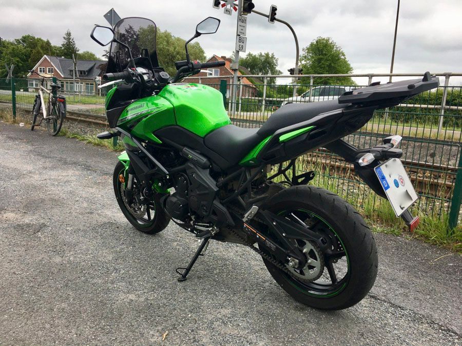 Ein grünes Kawasaki-Motorrad ist am Straßenrand geparkt.