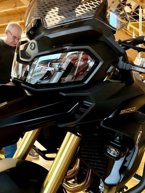 Ein Mann steht hinter einem schwarzen Motorrad mit der Nummer 800 auf der Vorderseite